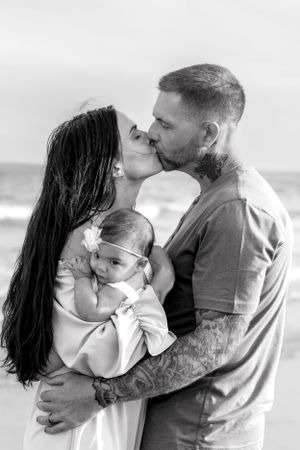 Black and white beach portraits showing tender family moments.