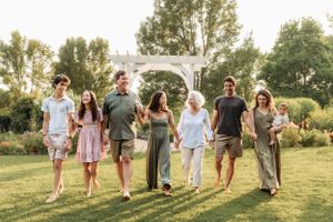 Family members walk together along a sunlit garden path during golden hour.
