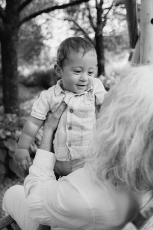 Black and white portraits showing tender moments between generations in an outdoor setting.