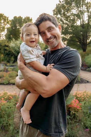 Playful outdoor portrait series showing joyful family moments in a garden.