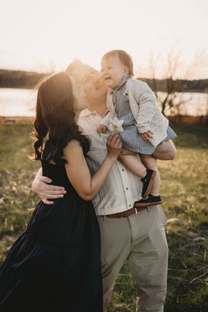 Candid family moments captured during golden hour in grassy field.
