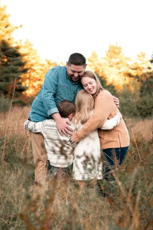 Candid family moments captured in a field during golden hour.