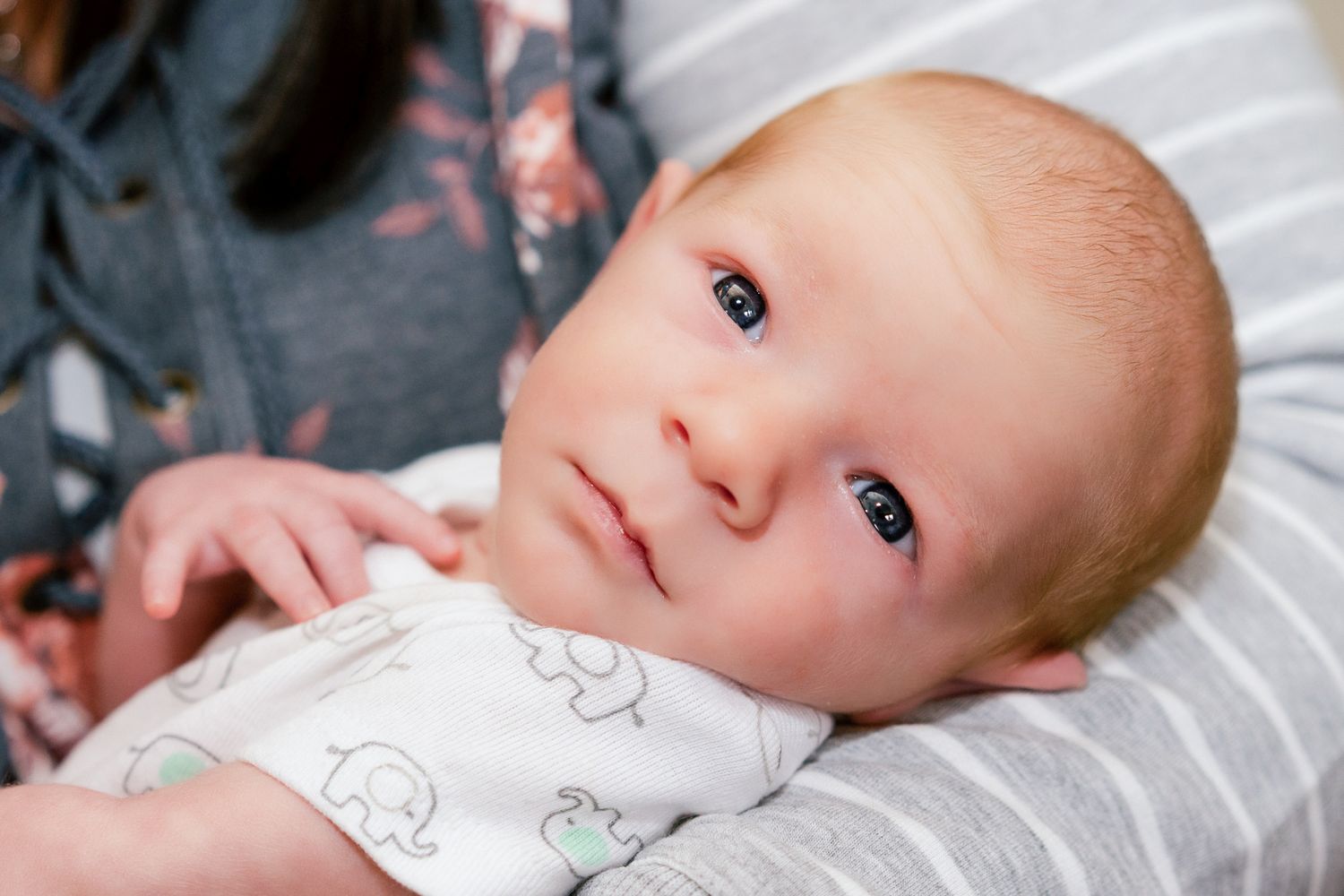 baby boy makes eye contact while mom holds him