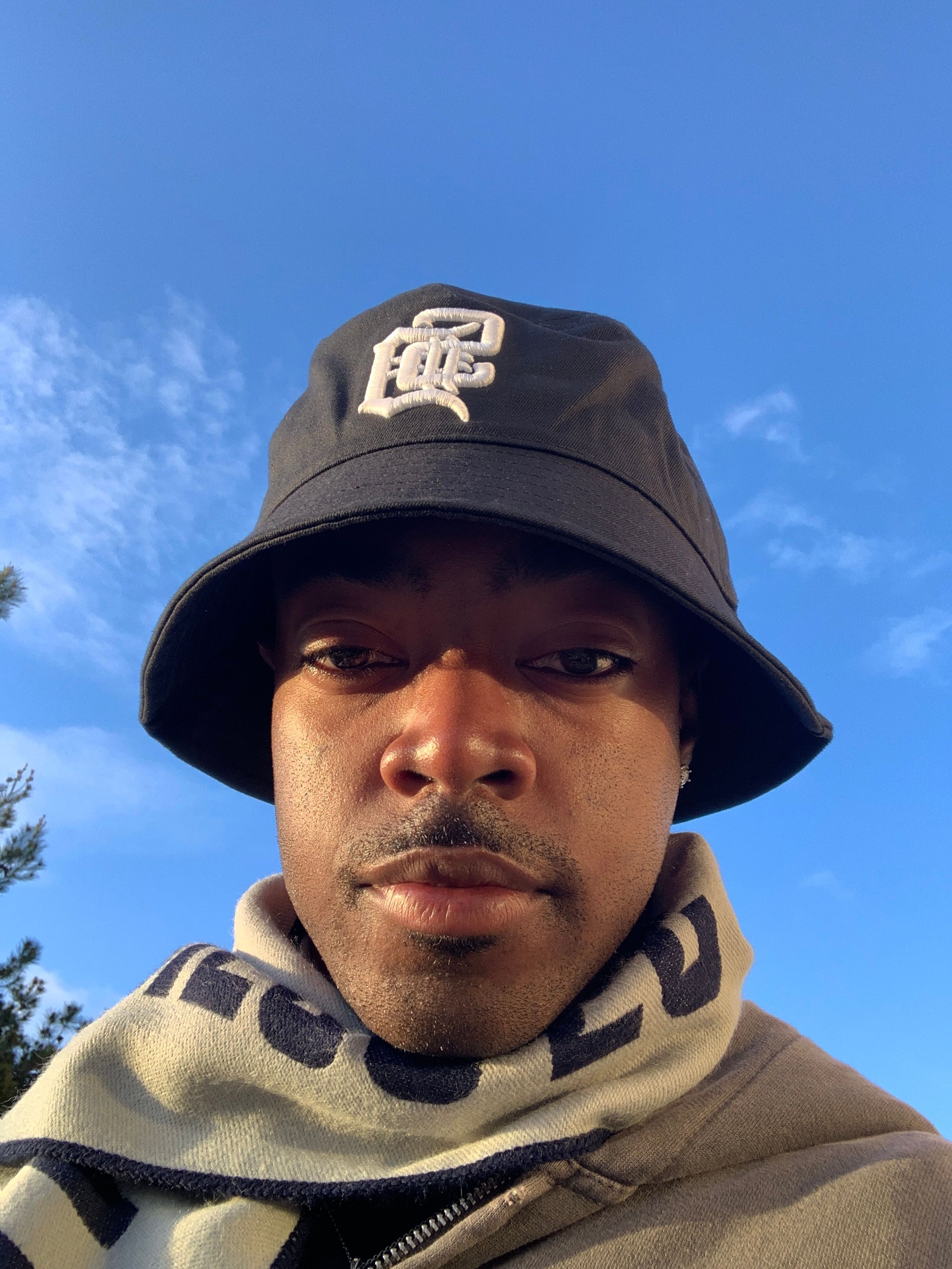 A model poses in a bucket hat with a scarf on