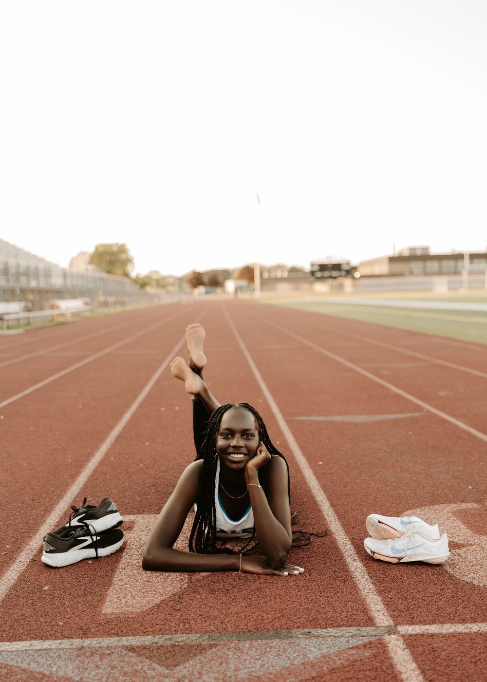 A sequence of four images showing a person lying on a running track with athletic shoes and workout gear.