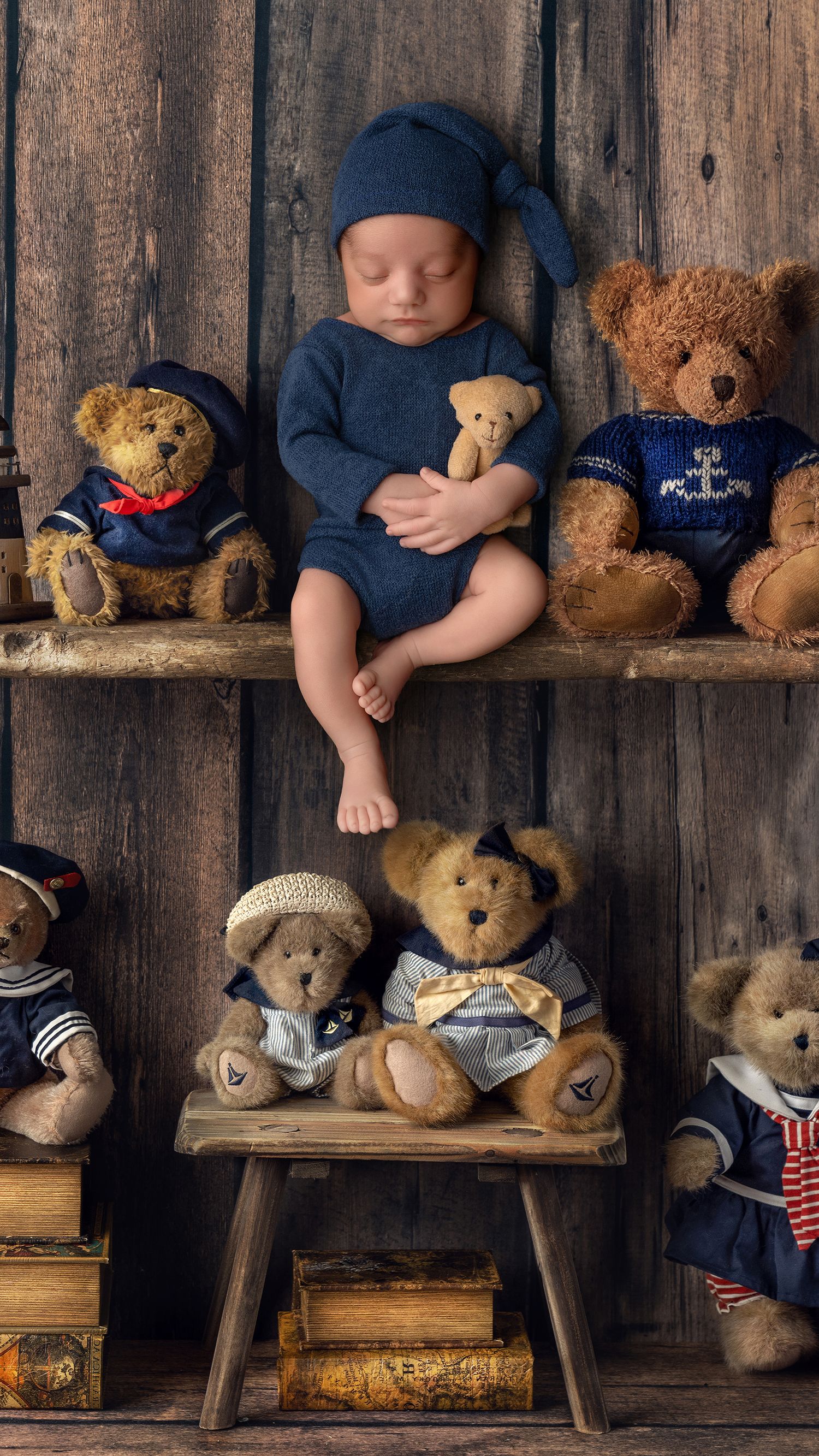 Newborn baby boy in blue outfit posed safely in West London studio