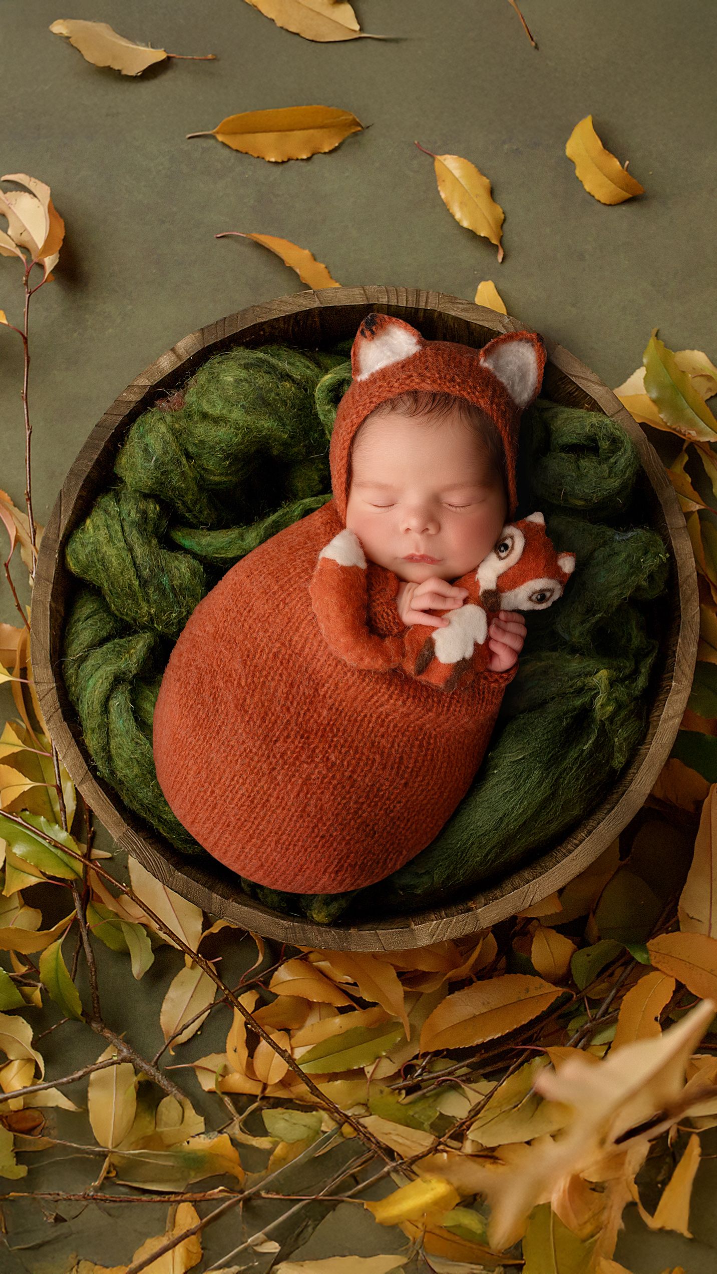 Sleepy newborn baby wrapped and posed as a fox during professional photoshoot in Hayes, West London