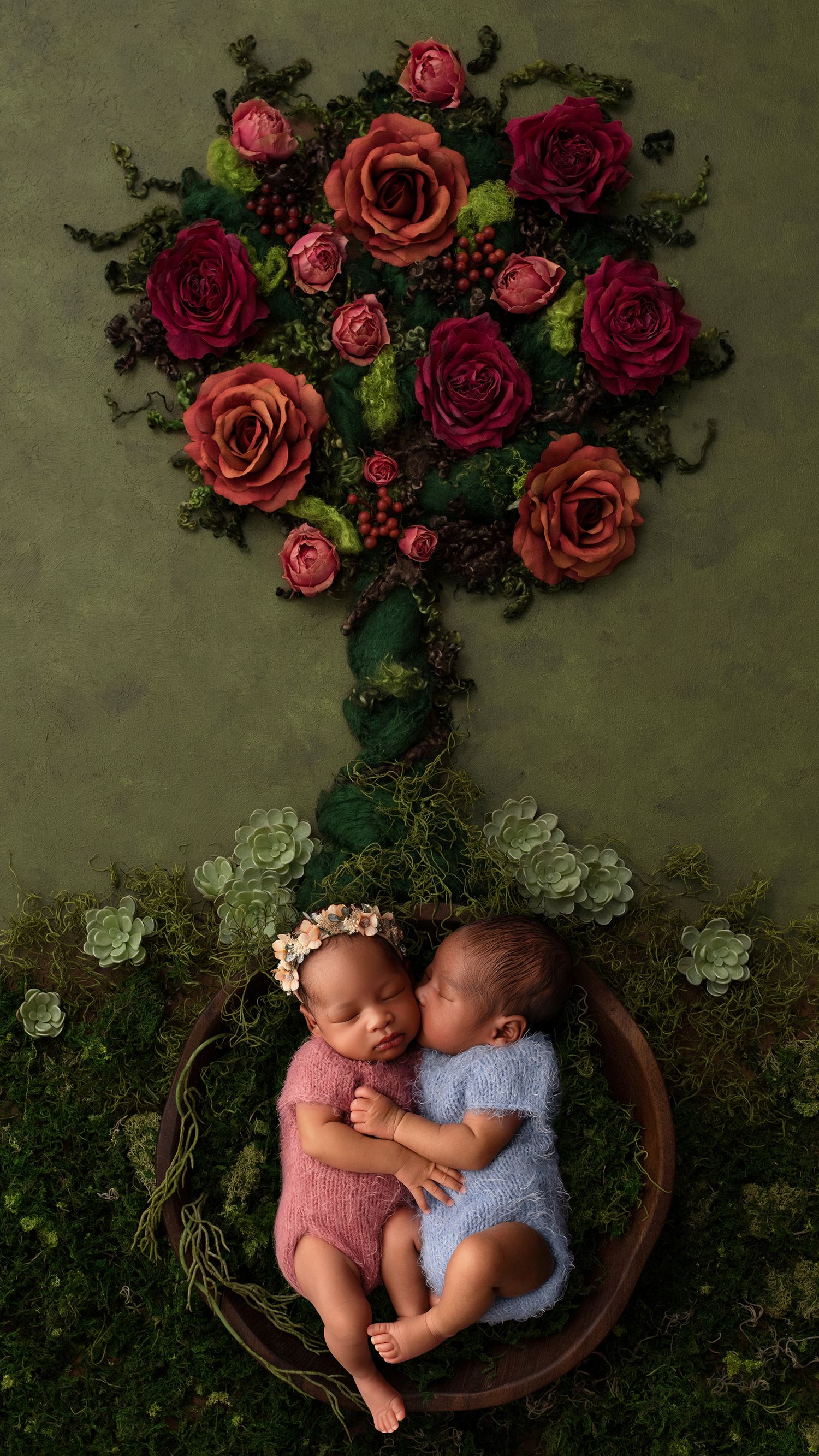 Sleeping newborn twin babies cuddling and holding each other during professional newborn photoshoot in Hayes, West London studio