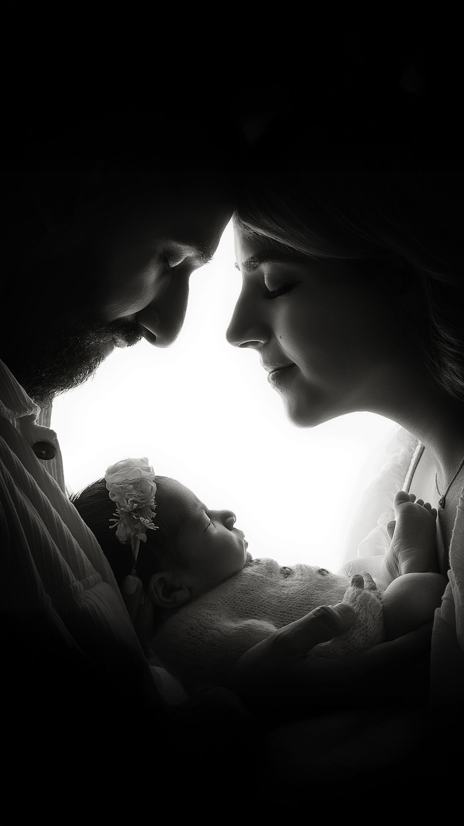 Newborn black and white family portrait with parents holding baby at West London studio