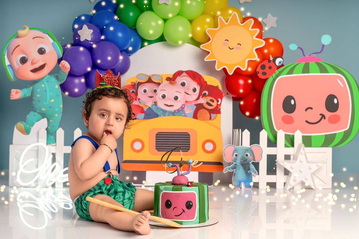 Baby covered in cake during fun first birthday photoshoot in Hayes studio