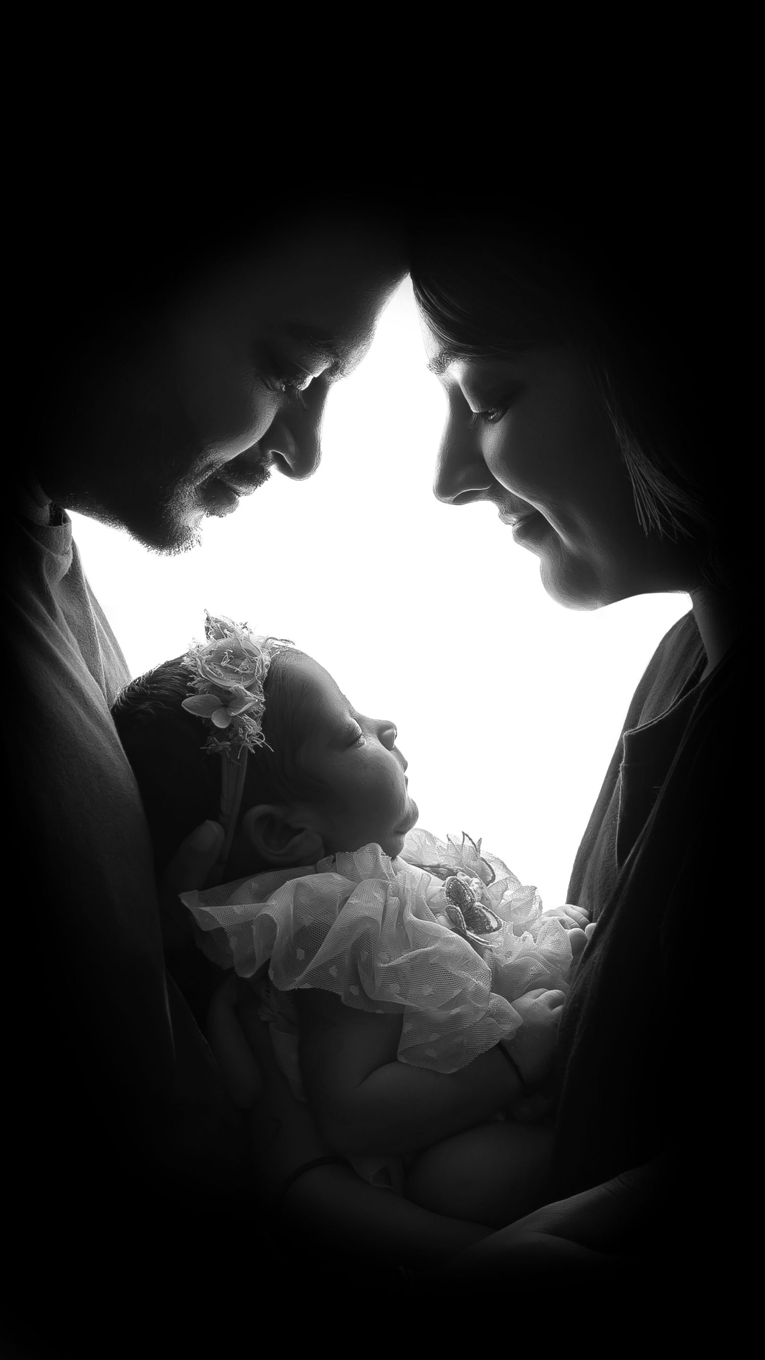 Black and white newborn portrait capturing parents holding their tiny baby in London photography studio