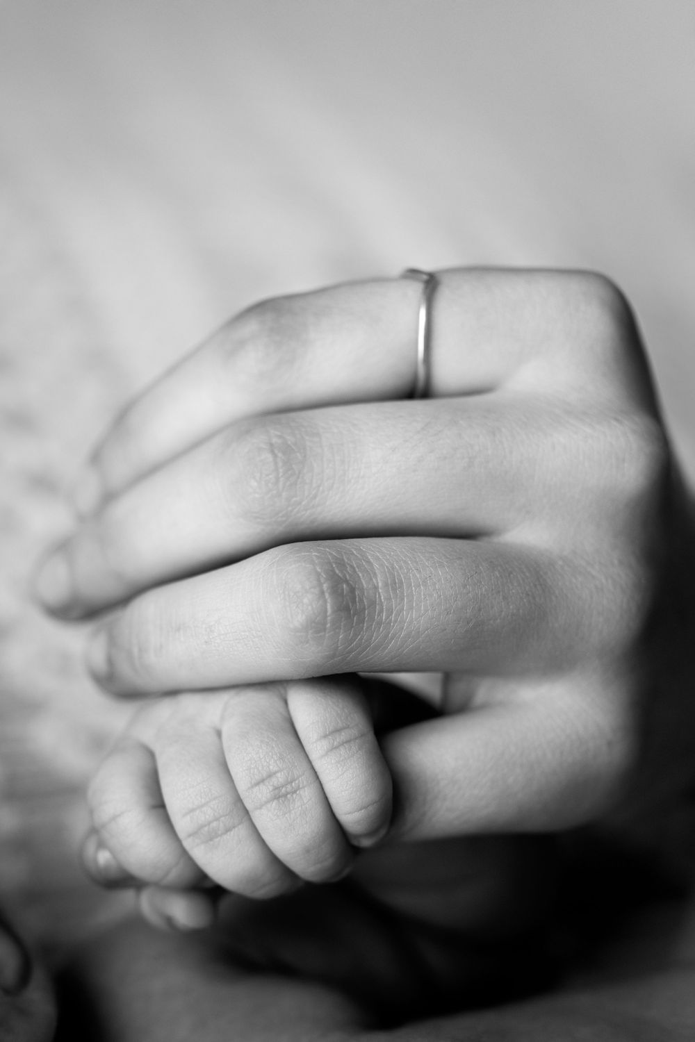 A series of black and white close-up photographs showing a baby's tiny hand from different angles.