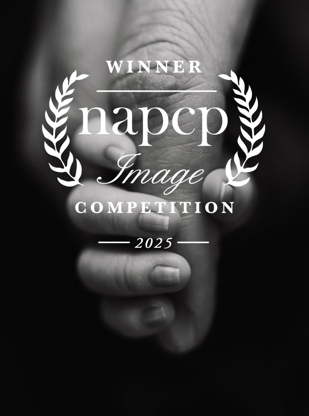 Black and white winner logo for NAPCP Image Competition 2023 with laurel wreath design on blurred background.