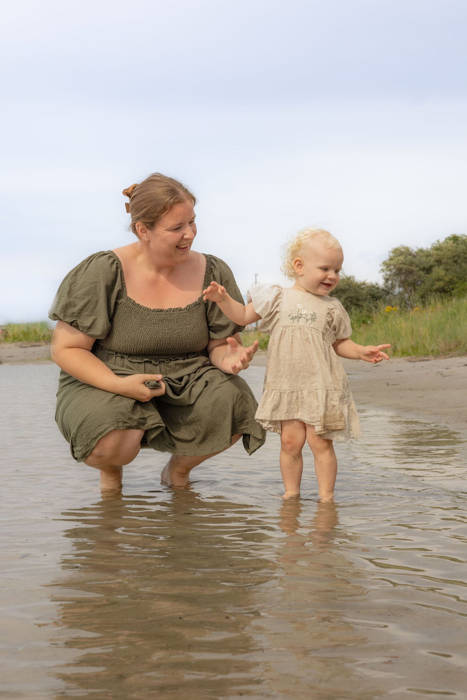 Family bonding moment as they splash and play in shallow coastal waters.