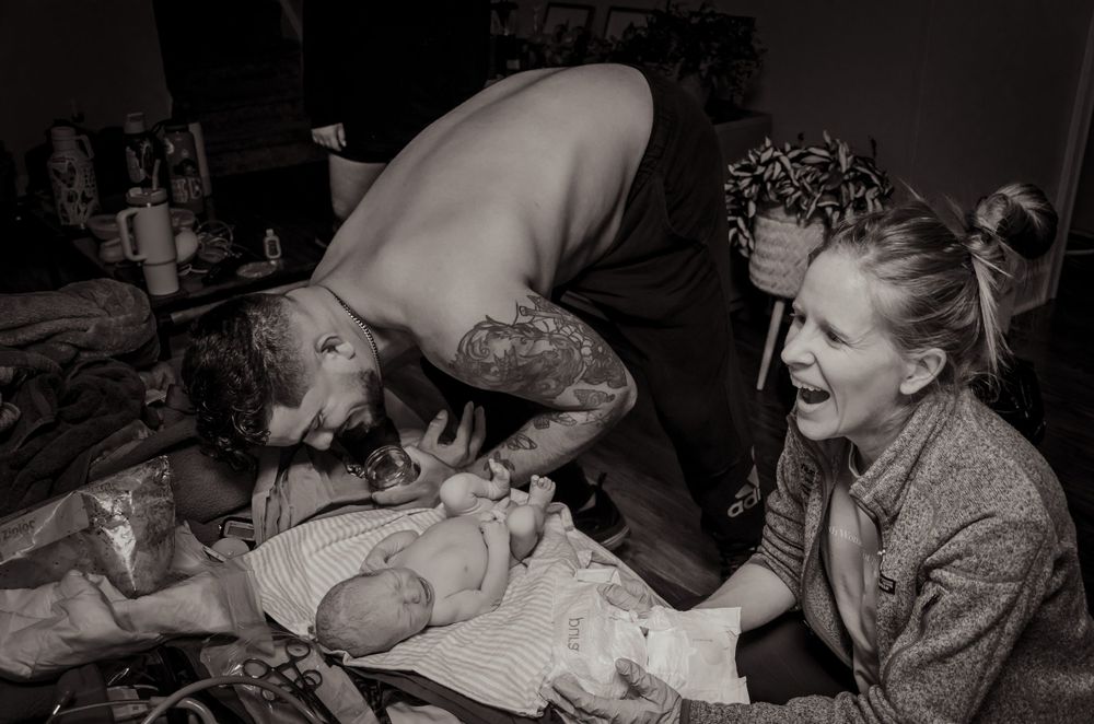 Emotional black and white capture of first moments with newborn baby.