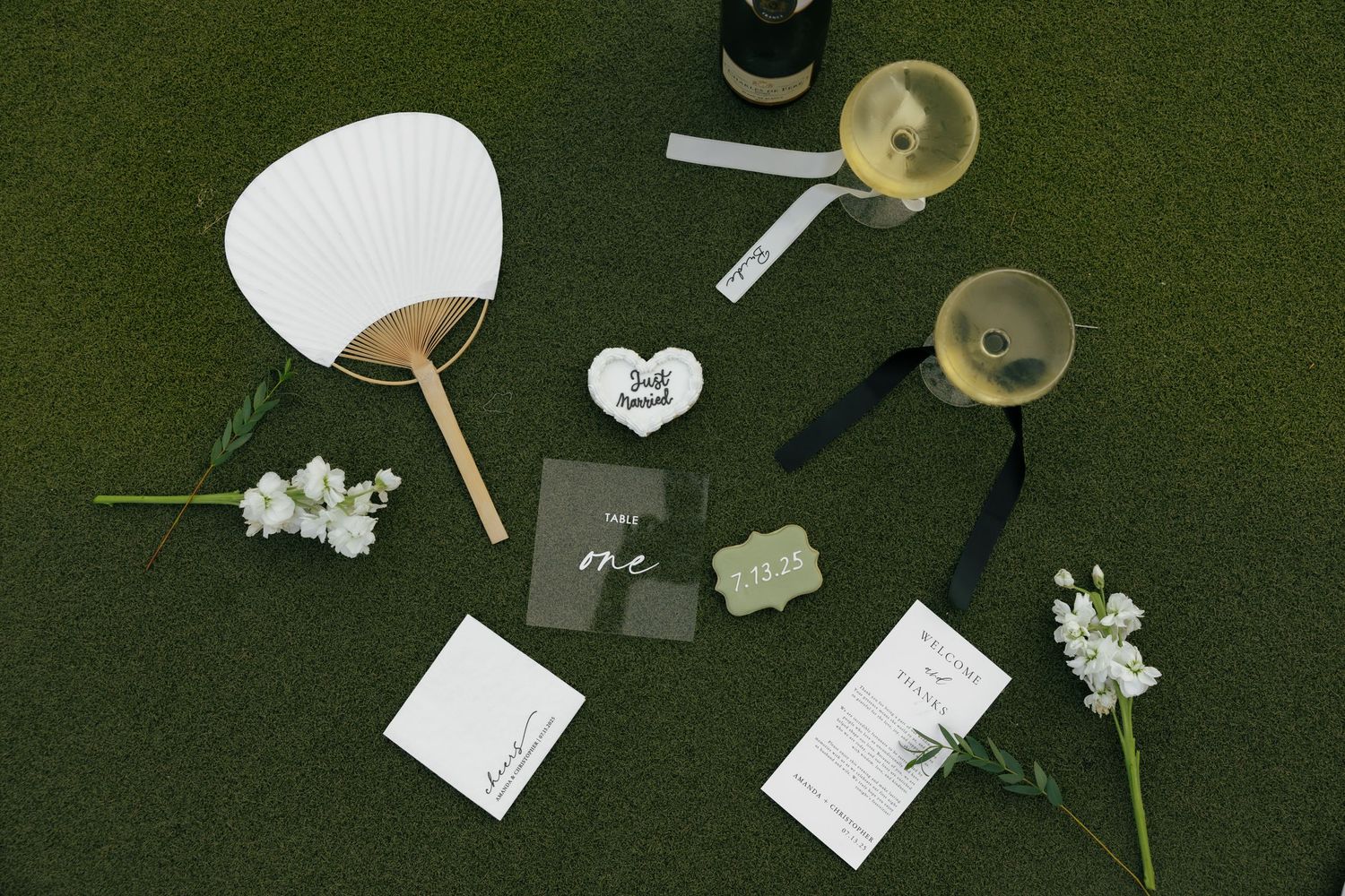 Elegant black and white wedding stationery with gold accents and stamps arranged on white linens.