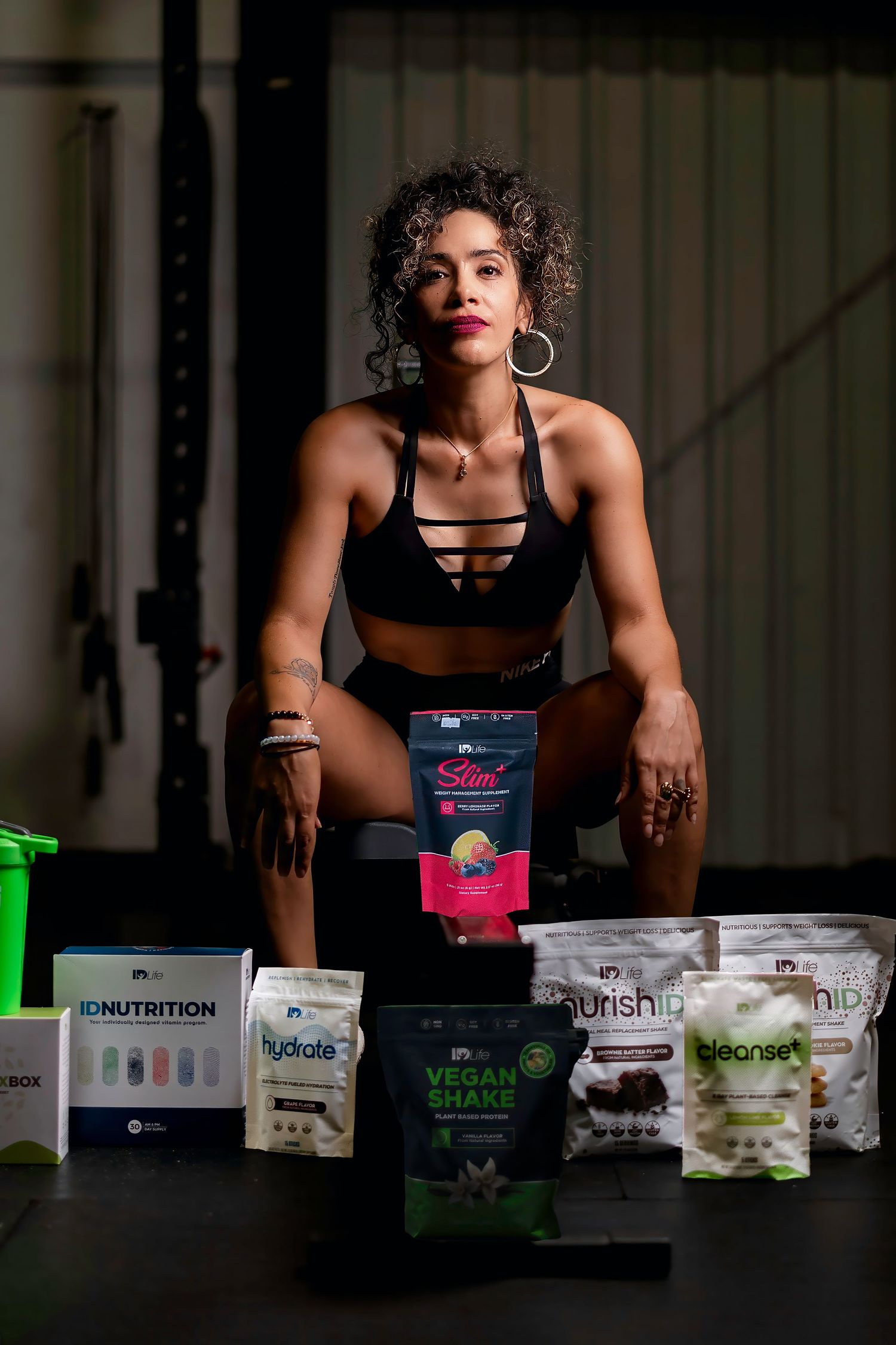 Fitness model showcasing various nutrition and supplement products in athletic wear.
