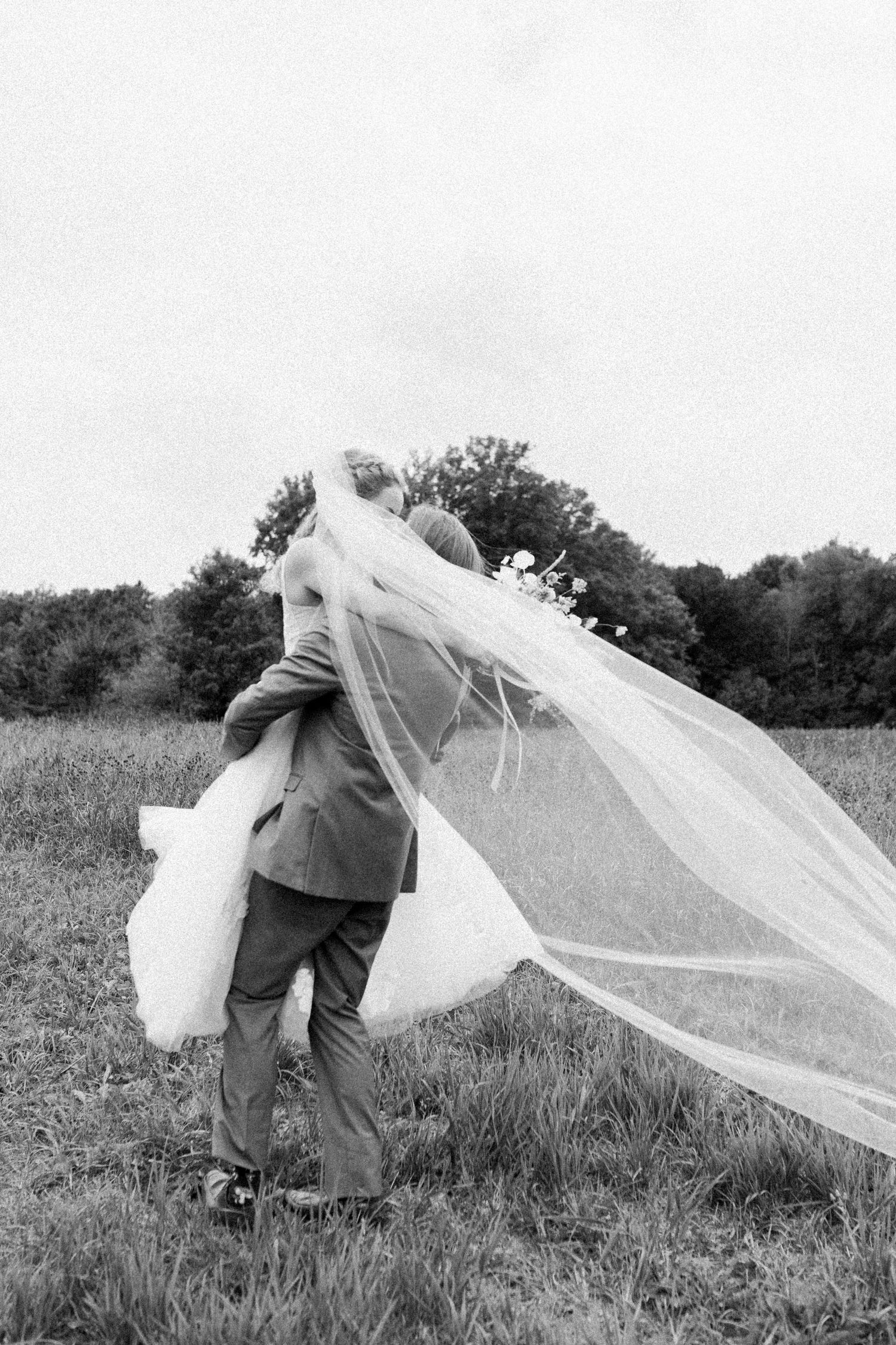 Groom lifts bride in a whimsical and romantic scene, joyfully spinning to symbolize the start of their shared journey.