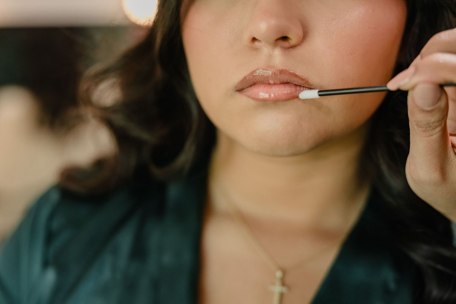 Close up of lip makeup application with small brush showing precise cosmetic detail.