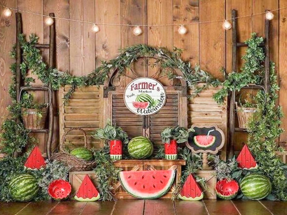 Rustic wooden backdrop with watermelon themed summer party decorations.