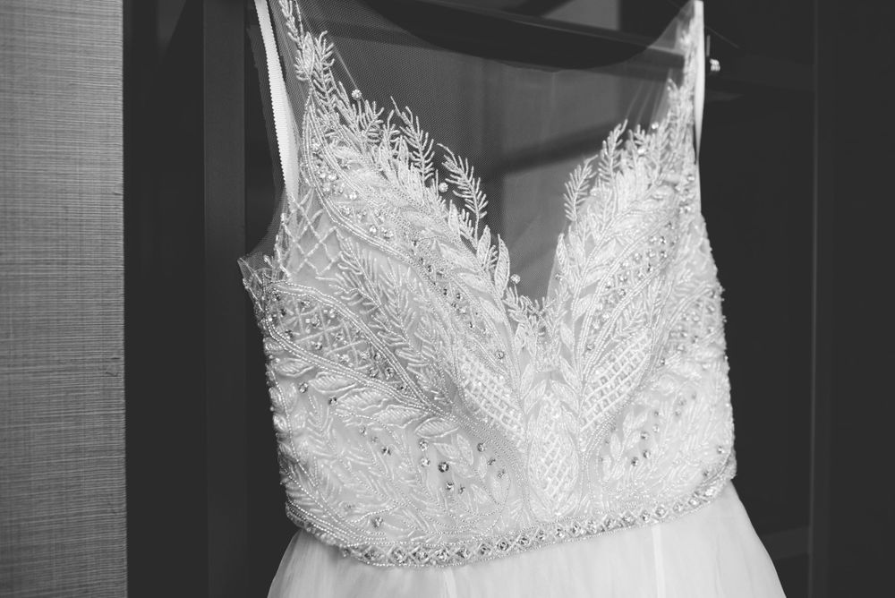 Close-up of a white wedding dress bodice featuring intricate lace detailing.