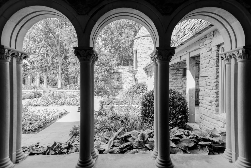 Beautiful stone archways frame a garden view at a historic wedding venue.