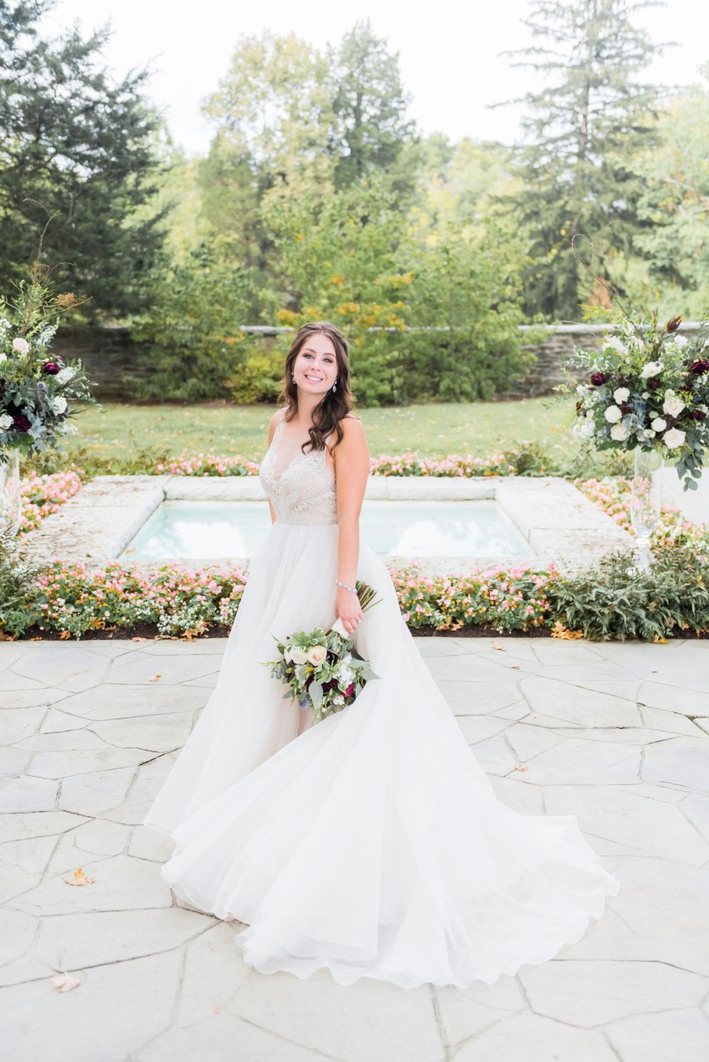 A wedding ceremony setup in a garden with stone pathways and floral arrangements.
