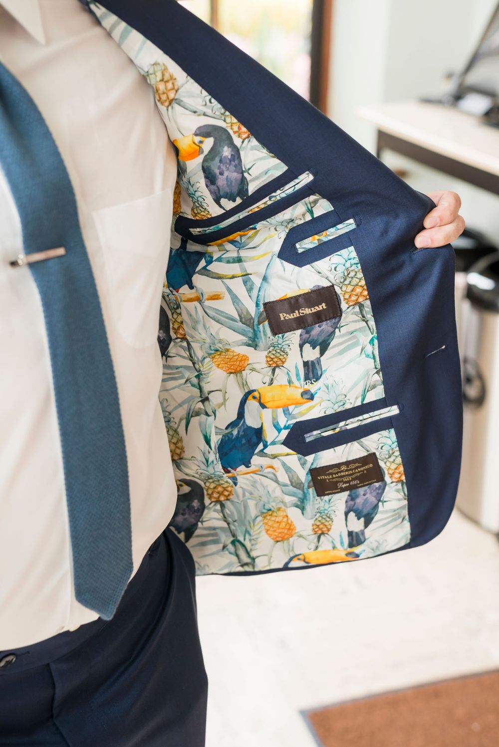 Navy suit jacket lining featuring whimsical floral and bird print design.