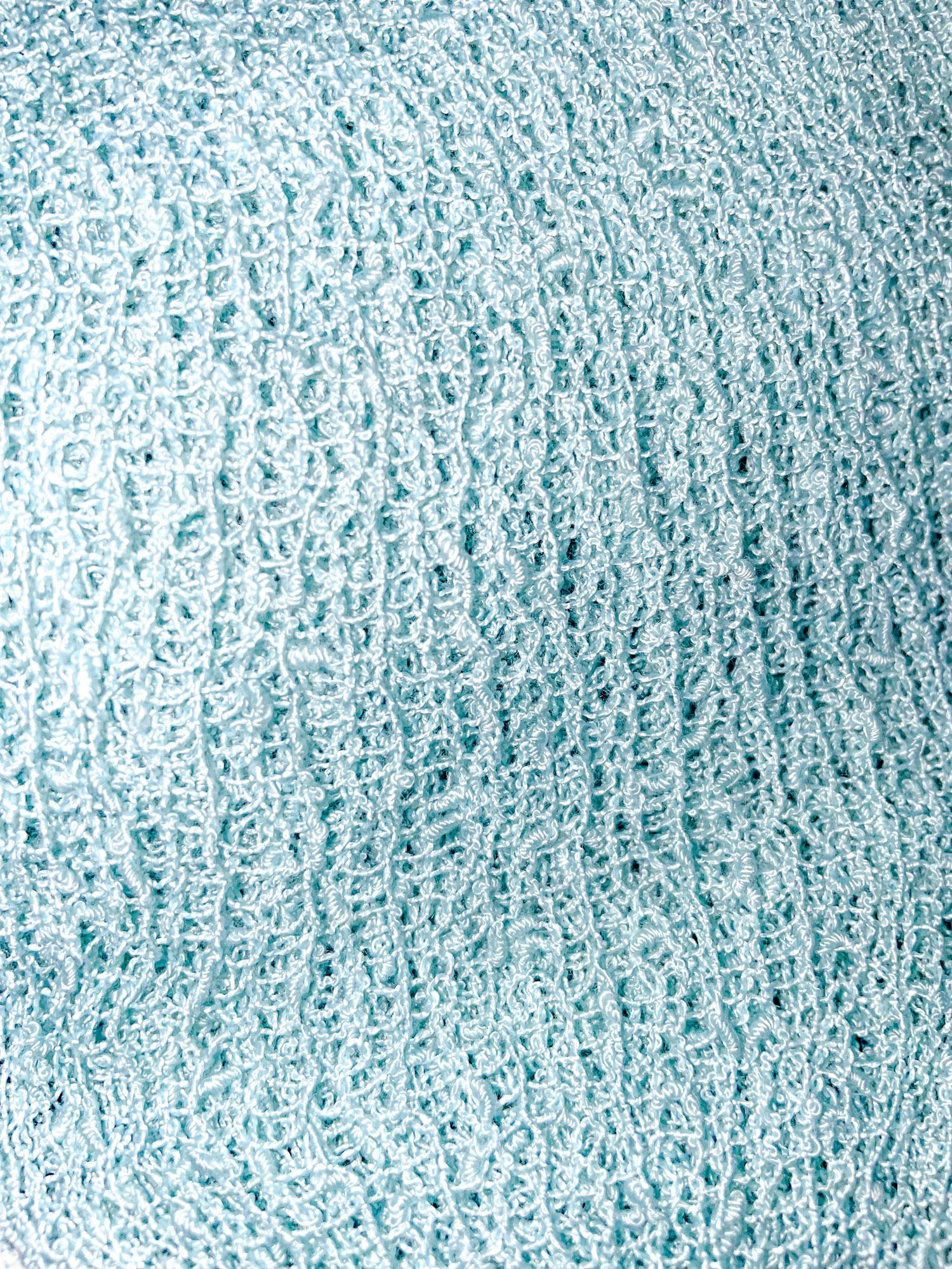 Light blue textured fabric with speckled pattern shown in close-up detail.