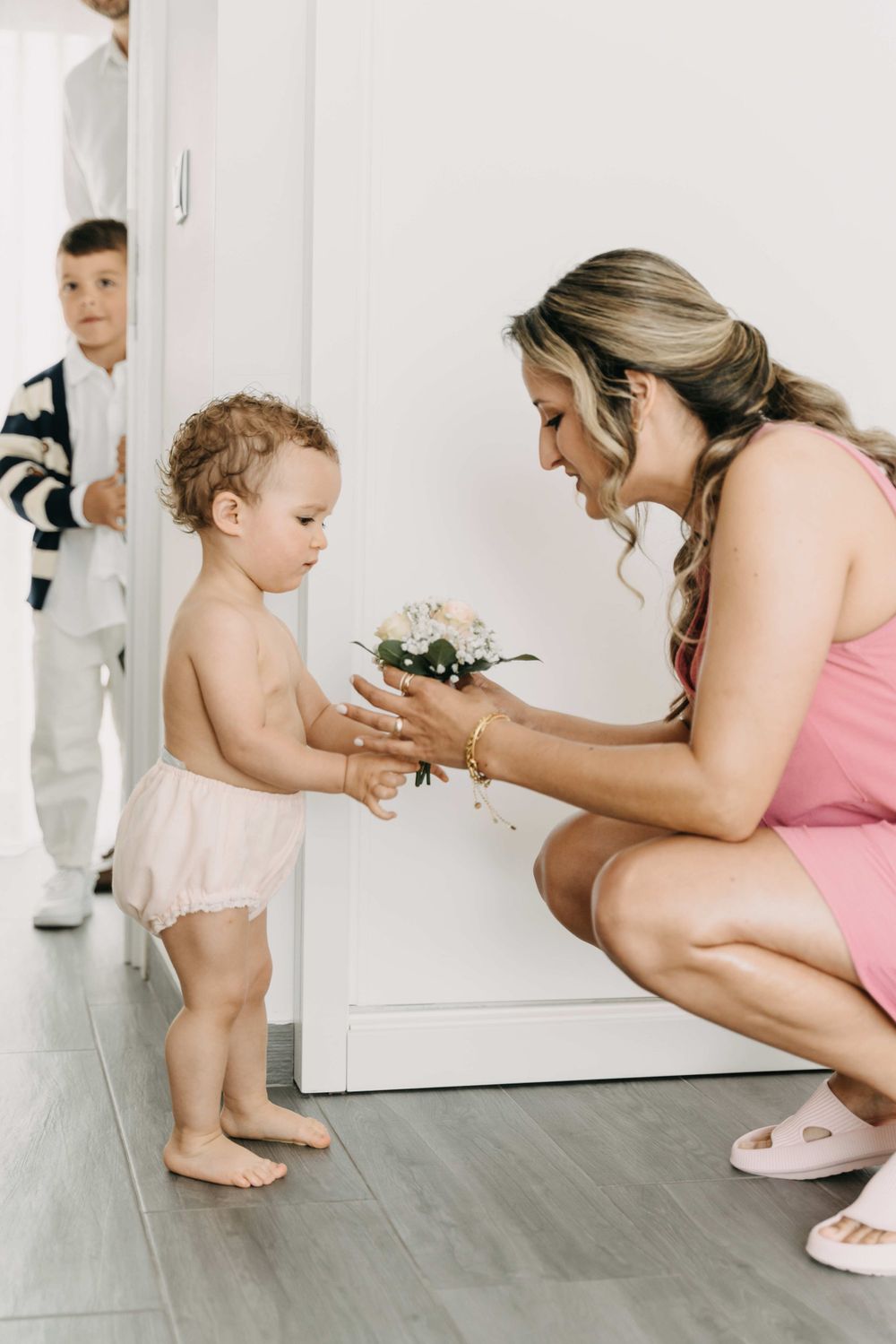 Sweet moment exchanging small floral bouquet in bright interior setting.