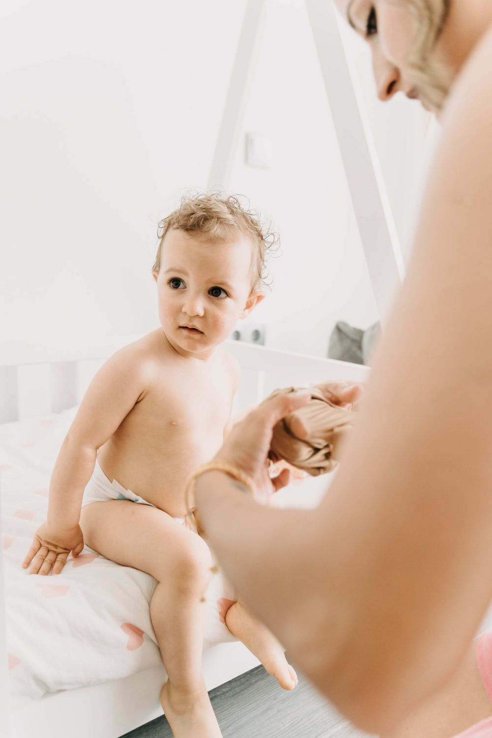 Getting ready moment with little one sitting on white surface.
