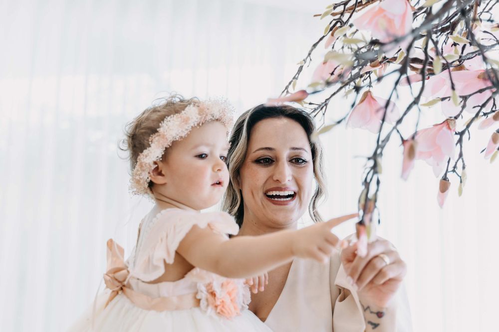 A tender moment shared while looking at cherry blossoms in soft lighting.