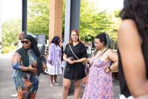Group of people chatting and socializing at an outdoor gathering.