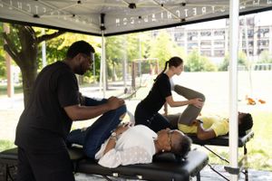 Person receiving a massage treatment on a portable table under a canopy tent.