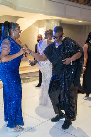 People in formal attire dancing and celebrating in an elegant venue.