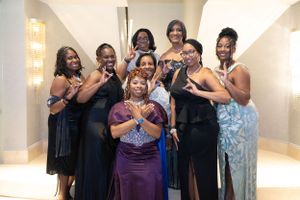 Friends gather for a fun group photo in formal attire at a special occasion.