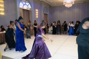 Guests dancing and mingling in formal attire at an elegant ballroom reception.