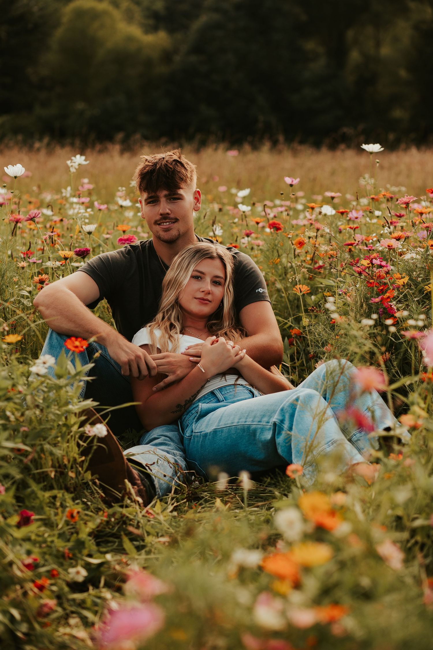 couple sitting in flowers together
