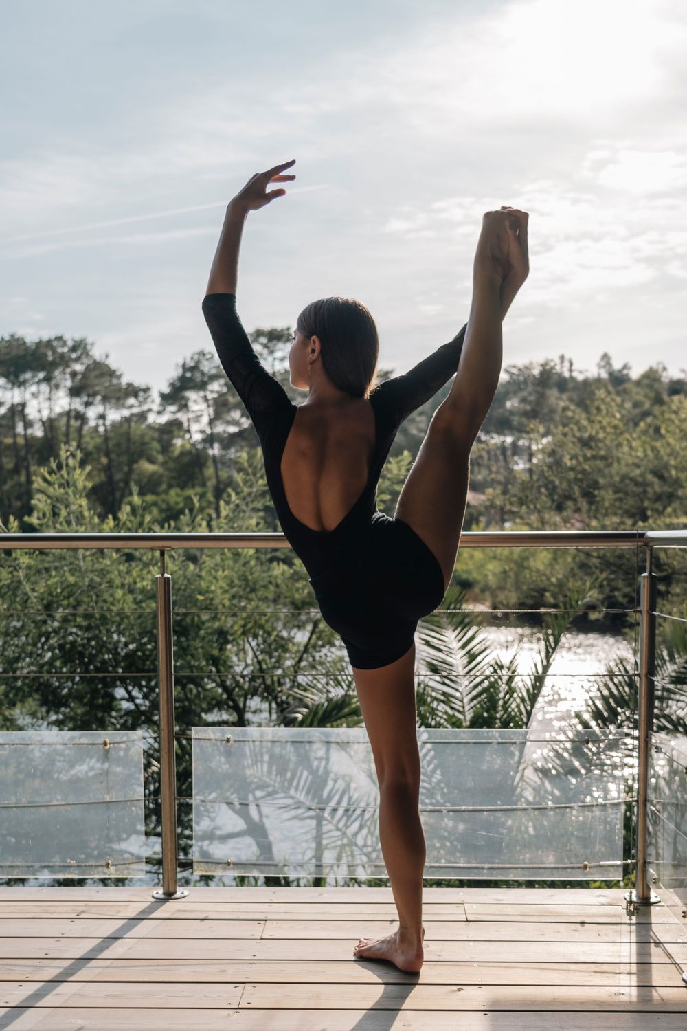 portrait danseuse en extérieur, pied dans la main de dos avec bras couronne.