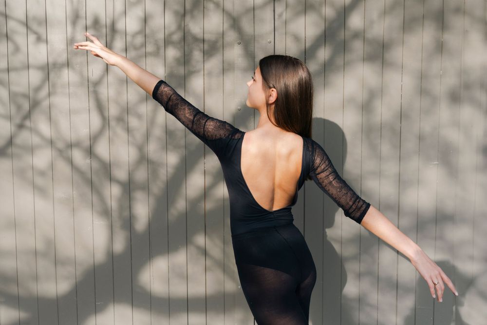 portrait danseuse en extérieur, port de bras de dos pour montrer le dos du justaucorps.
