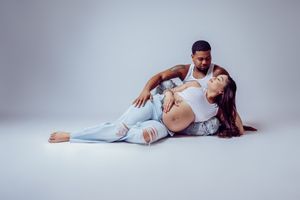 Artistic dance pose of couple in intimate embrace on studio floor.