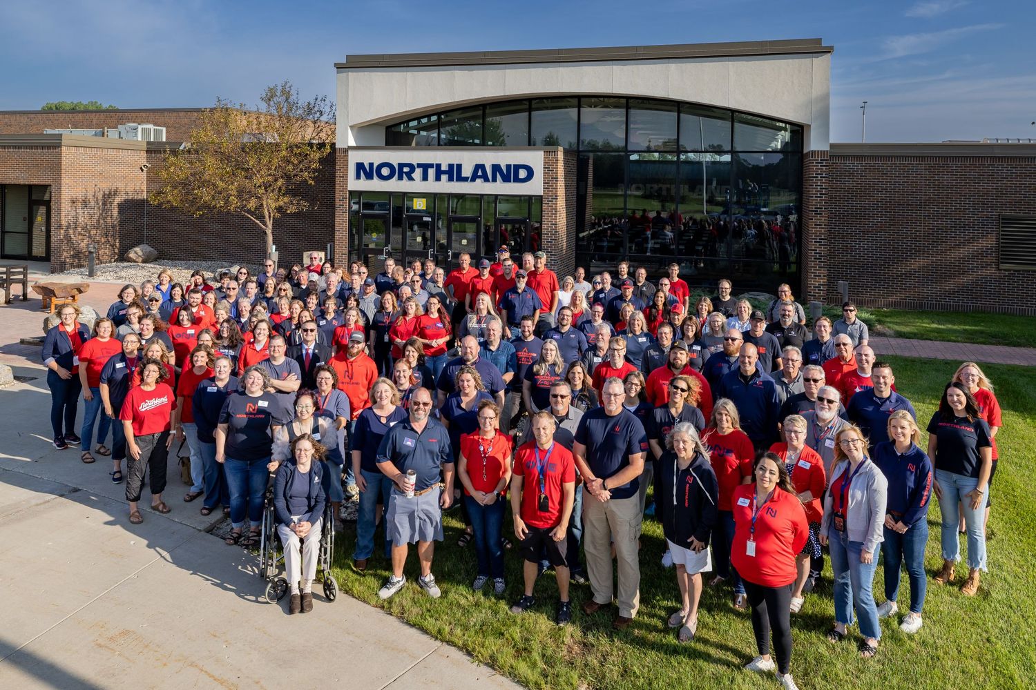 Large group of employees gathered outside various corporate office buildings.