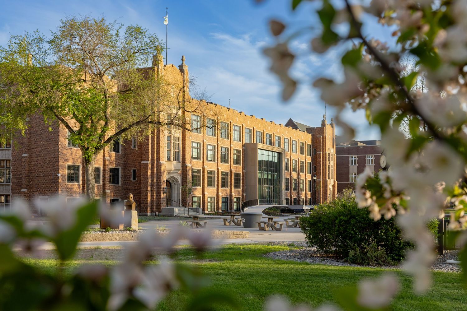 Brick school building facade with classic architecture and landscaping under blue sky.
