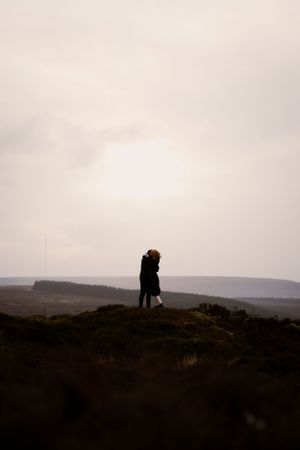 A tender moment suspended in time — love standing tall against the vast horizon.