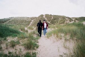 A tender moment captured in the dunes — a soft, timeless and intimate. LGBTQ+ engagement
