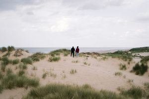 A tender moment captured in the dunes — a soft, timeless and intimate. LGBTQ+ engagement