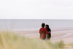 A tender moment captured in the dunes — a soft, timeless and intimate. LGBTQ+