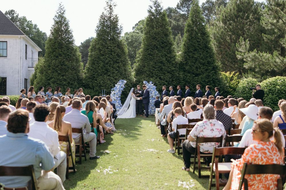 Wedding ceremony setup with wooden chairs arranged in rows on a green lawn. The Bradford, Separk  Mansion, Graylyn Estate