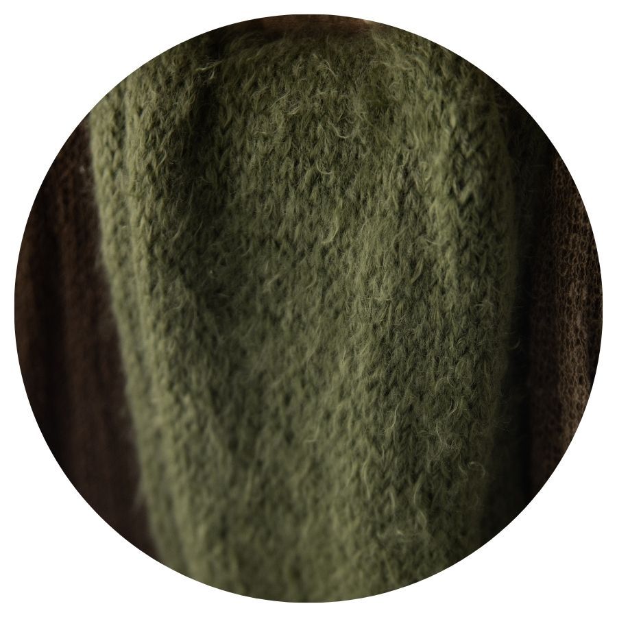 Close-up of a soft, fuzzy olive green knitted fabric with a fluffy texture.