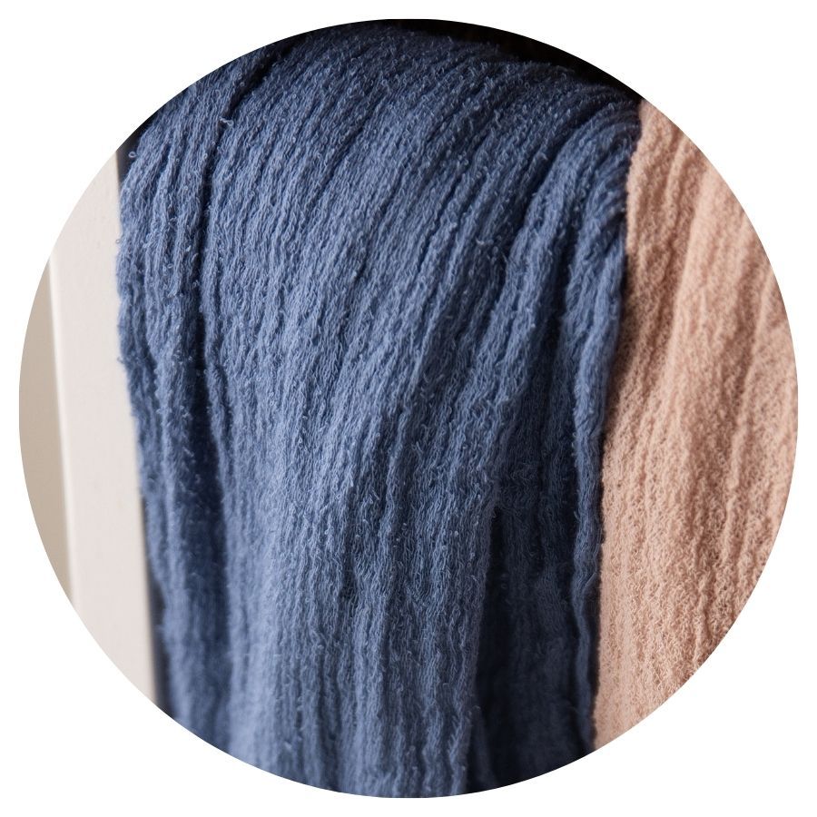 Close-up of draped blue and blush pink loosely woven textile fabrics.